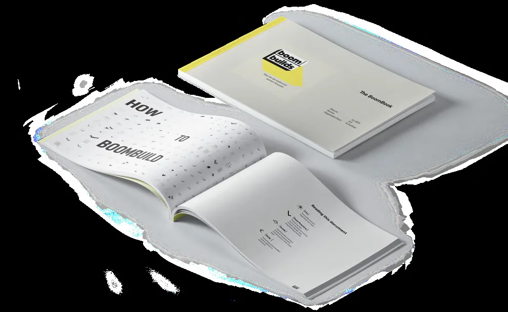 Photograph of the printed BoomBook lying open, showing its yellow-accented layout